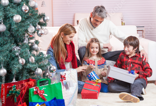 Happy family exchanging gifts for Christmas