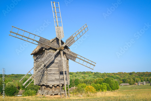 Old windmill in the field under blue sky