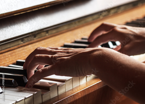 Close up of female hands playing piano photo