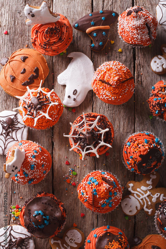Halloween cupcakes and gingerbread cookies closeup. vertical top view
