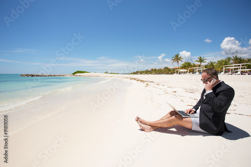 Busy businessman working on the beach photo