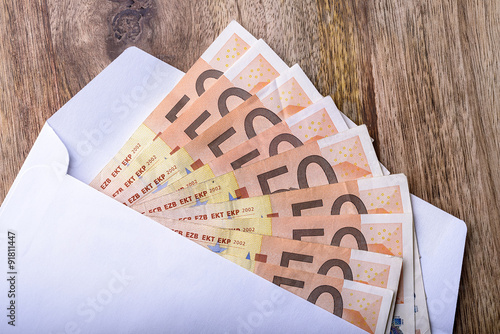 envelope full of money euro on wood for concept
