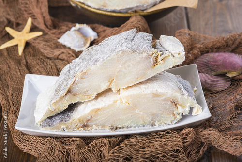 Foto Lomos de bacalao salado cortados, pescado seco conservado en sal sobre fondo de