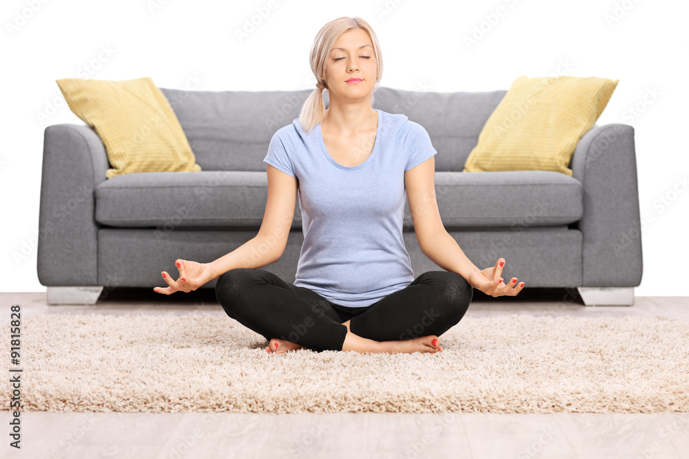 Peaceful woman meditating seated on the floor Peaceful woman meditating seated on the floor