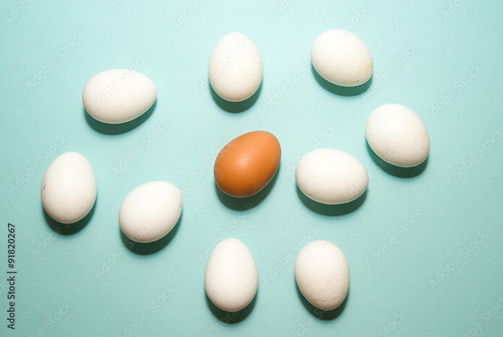 Chicken eggs of different colors on blue surfase
