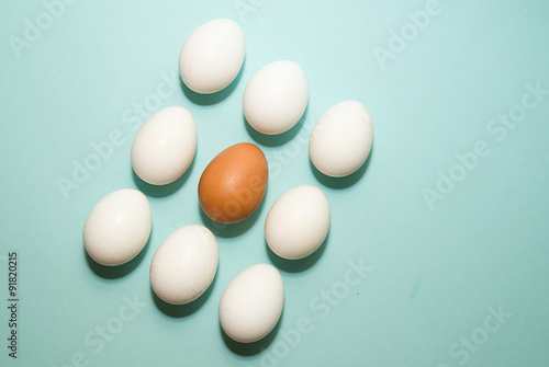 Chicken eggs of different colors on blue surfase