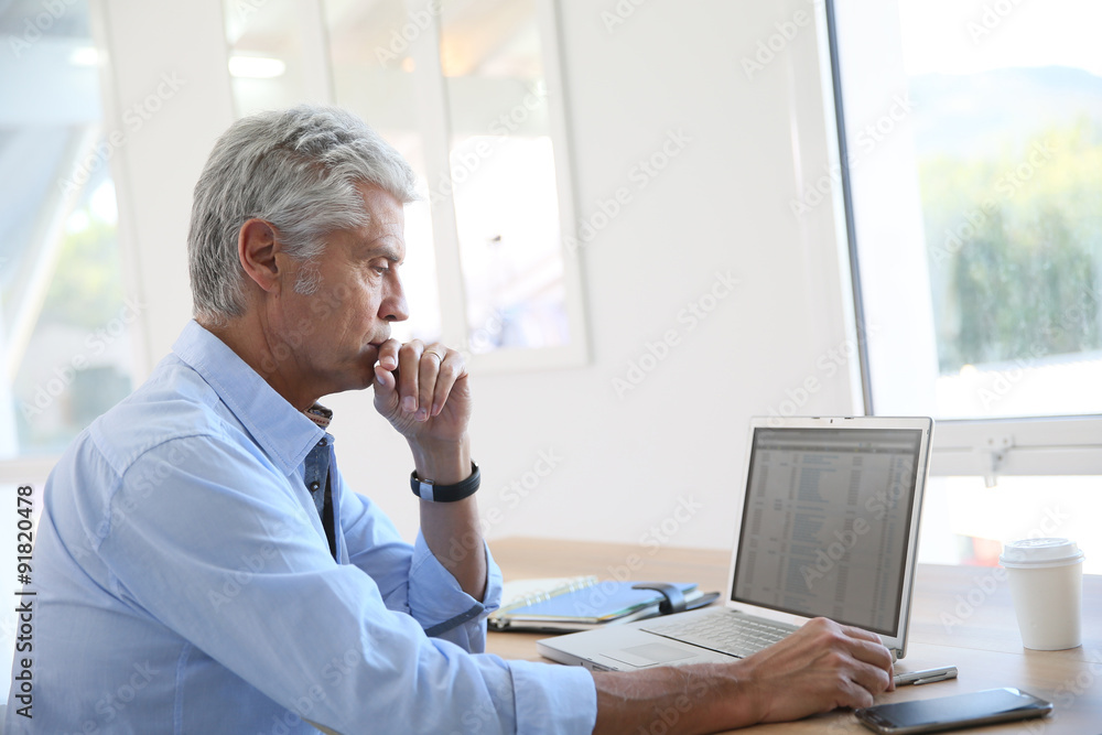 Senior businessman working on laptop computer Senior businessman working on laptop computer