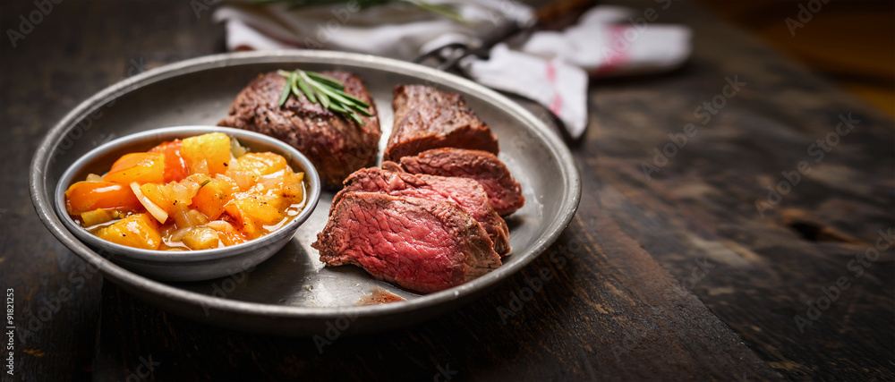 Slices of medium rare roasted meat steak and salsa sauce Slices of medium rare roasted meat steak and salsa sauce