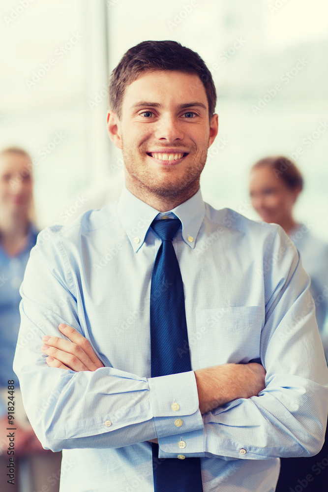 smiling businessman with colleagues in office