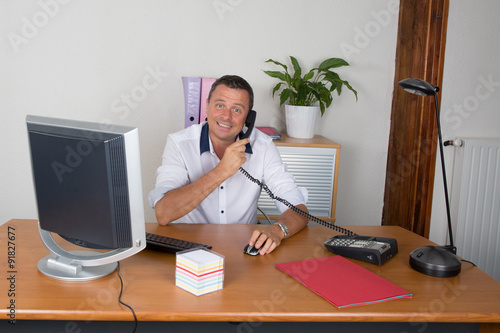 Manager man at his desk at work photo