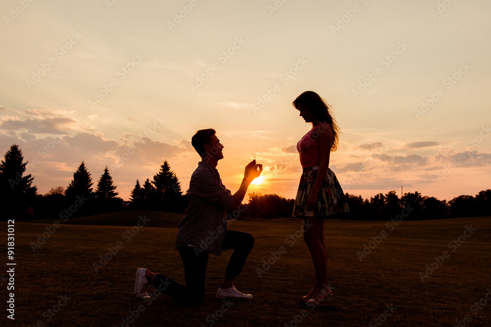 silhouette of a man makes a proposal of betrothal to his girlfri