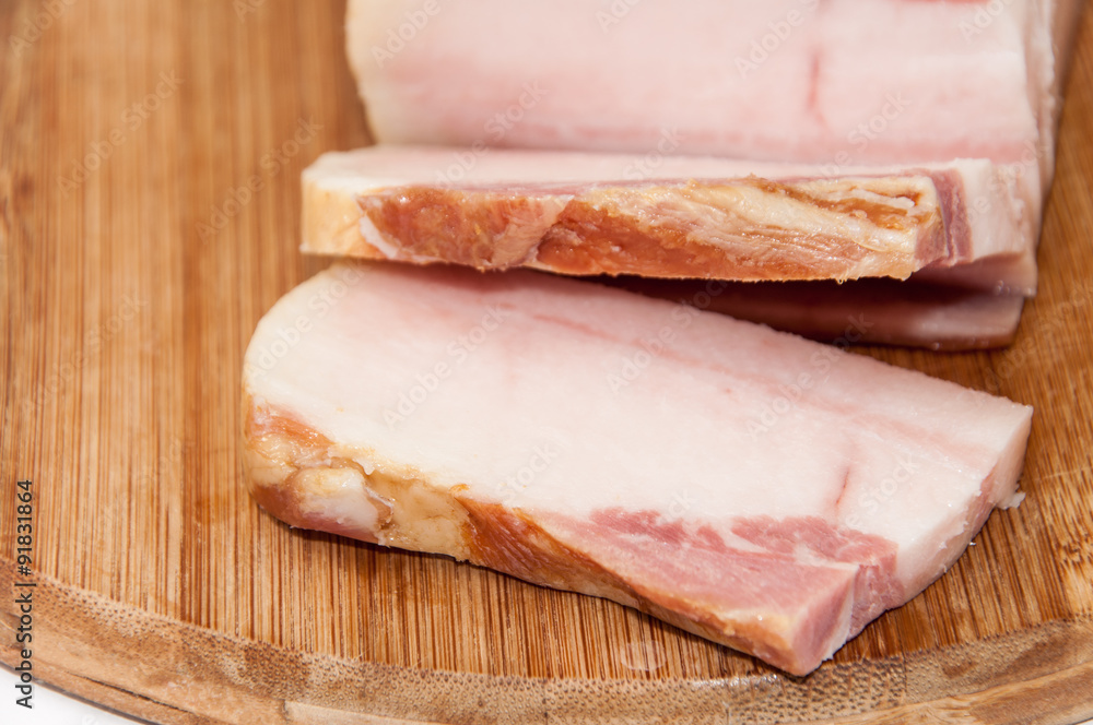 Sliced smoked bacon on the wooden board Sliced smoked bacon on the wooden board