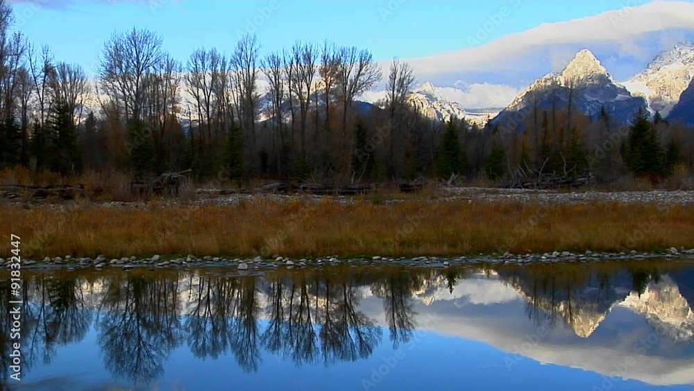 The Grand Teton mountains are perfectly reflected in a mountain lake. The Grand Teton mountains are perfectly reflected in a mountain lake.