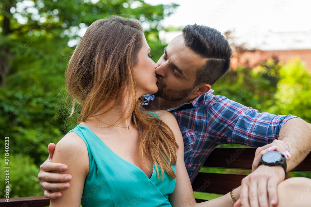 Couple sitting on the bench, they are in love.