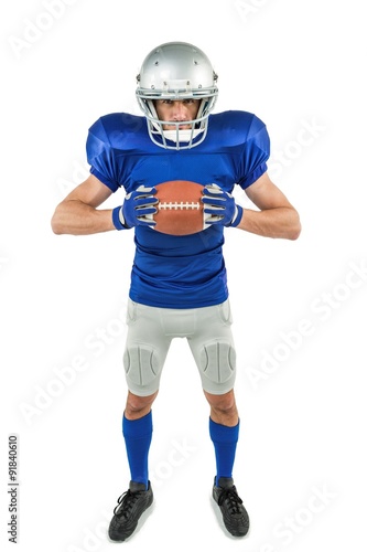 Full length portrait of American football player holding ball