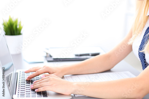 Close up of business woman hands typing on laptop computer  blue tie with polka dots
