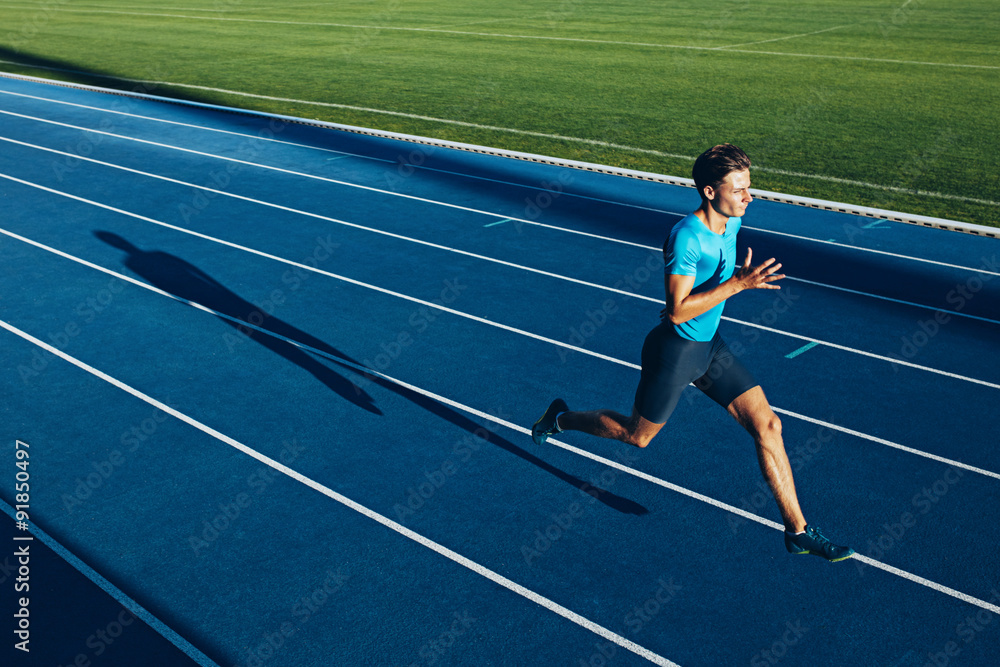 Obraz premium Young male athlete training on a race track