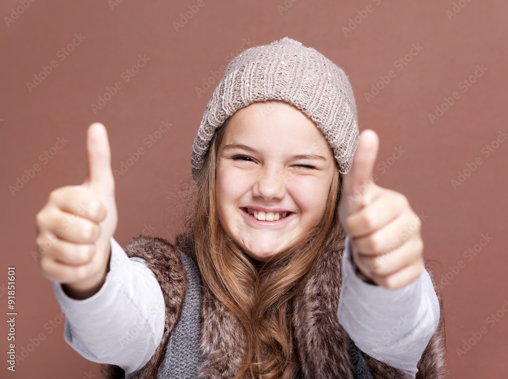 Portrait of a beautiful girl showing thumbs on brown background Portrait of a beautiful girl showing thumbs on brown background
