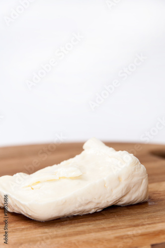 Homemade white cheese on the kitchen wooden board