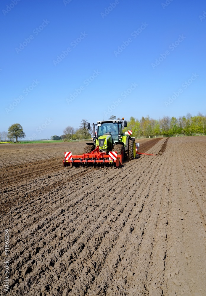 Obraz premium Trecker mit landwirtschaftlichen Geräten beim Mais legen