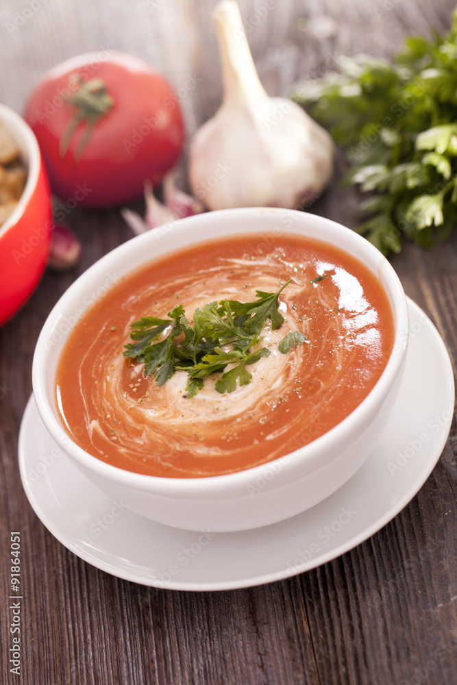 Delicious tomato soup with aromatic spices on a wooden table. Delicious tomato soup with aromatic spices on a wooden table.