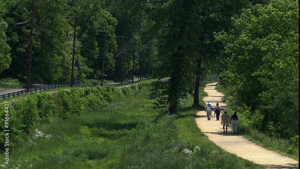Unidentifiable walkers on c & O canal tow path in National Historic Site Unidentifiable walkers on c & O canal tow path in National Historic Site