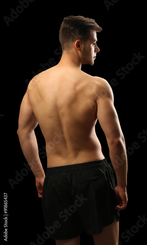Muscle young man on dark ba...