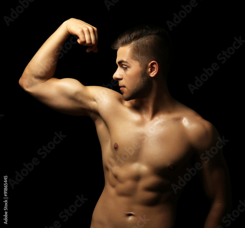 Muscle young man on dark ba...