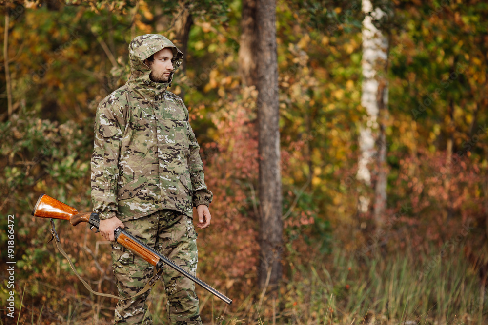 Young male hunter in camouflage clothes ready to hunt with hunt Young male hunter in camouflage clothes ready to hunt with hunt