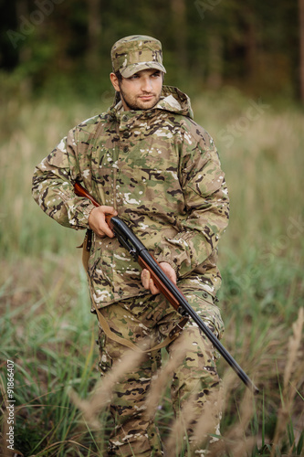 Young male hunter in camouflage clothes ready to hunt with hunt