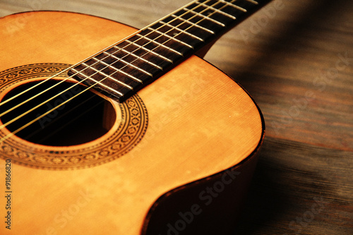 Acoustic guitar on wooden background