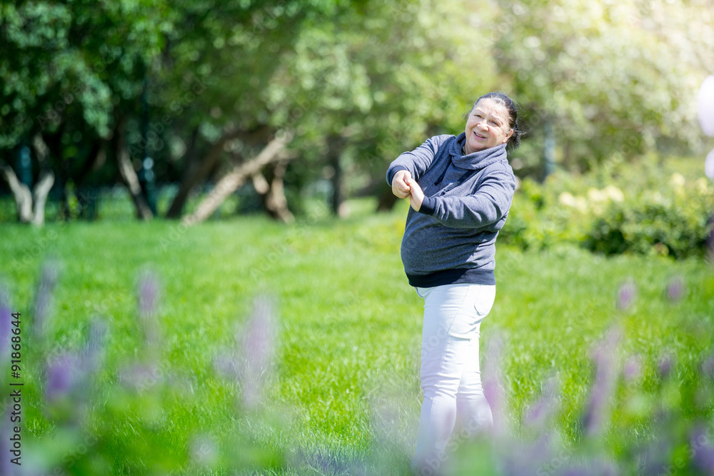 Senior woman doing exercises in green beautiful park. Healthy lifestyle Senior woman doing exercises in green beautiful park. Healthy lifestyle