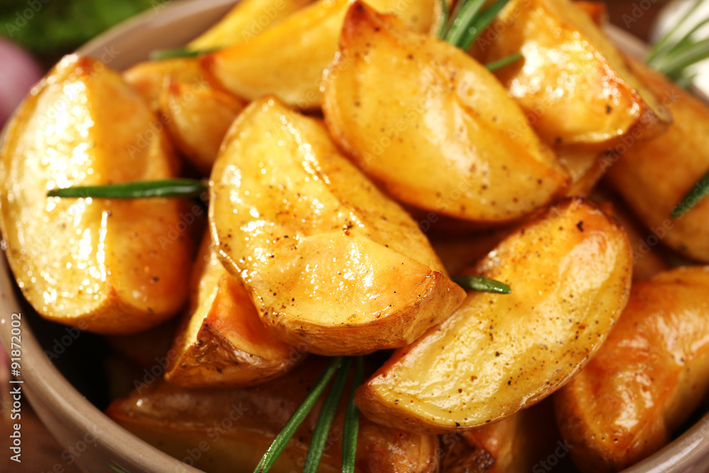 Baked potato wedges in bowl, closeup Baked potato wedges in bowl, closeup