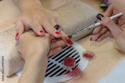painting nails in nail salon  manicure  focus on the finger