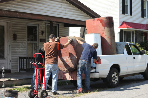 Men loading heavy scrap metal into truck