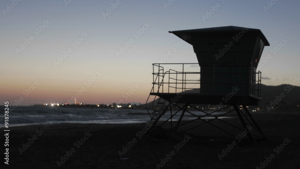 A lifeguard tower stands in sand on a beach. A lifeguard tower stands in sand on a beach.
