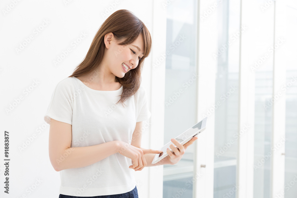 部屋でタブレットを見る女性 部屋でタブレットを見る女性