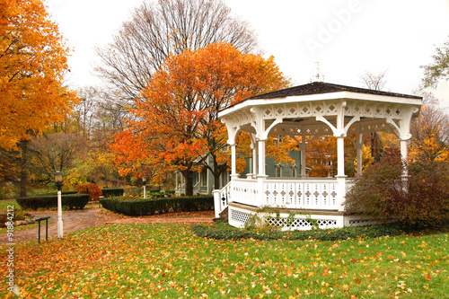 Fotografía White Gazebo and autumn trees in the park