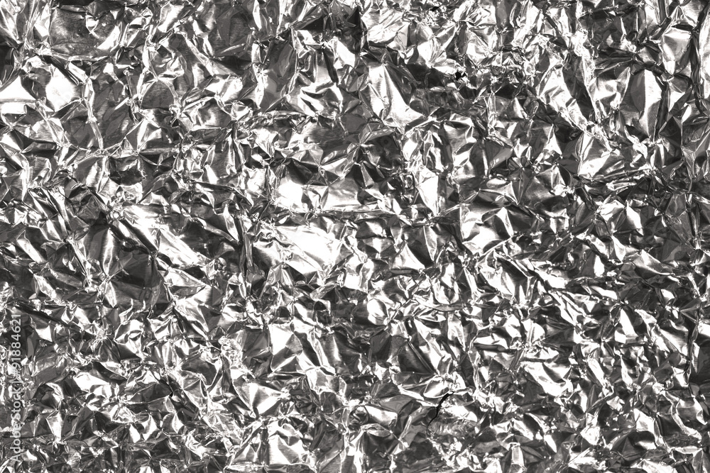Silver wrinkled and shrunken foil surface, crinkly, crushed metallic background Silver wrinkled and shrunken foil surface, crinkly, crushed metallic background