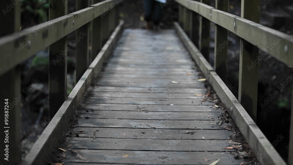 Person wearing socks (but no shoes) runs over wooden bridge. Person wearing socks (but no shoes) runs over wooden bridge.