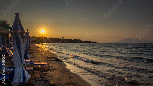 Sunset on beach with parasol in foreground