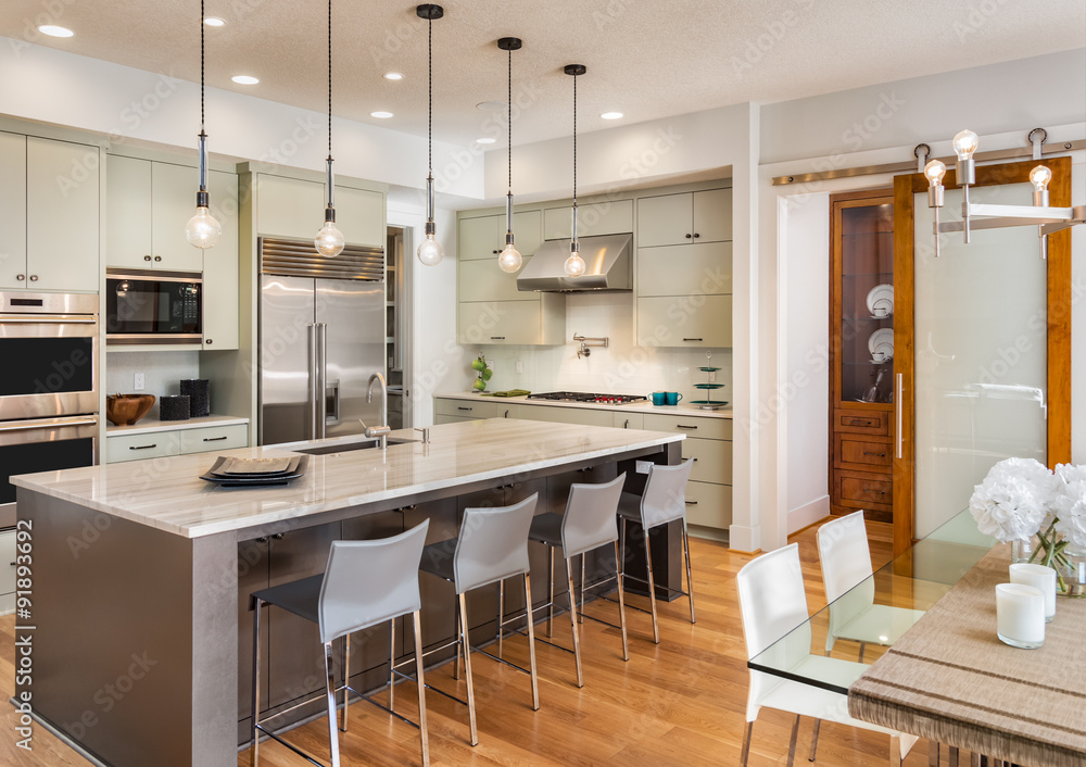 Beautiful Kitchen and Dining Room in New Luxury Home, with Island, Stainless Steel Refrigerator, Microwave, Range, Oven, Chairs, and Pendant Lights Beautiful Kitchen and Dining Room in New Luxury Home, with Island, Stainless Steel Refrigerator, Microwave, Range, Oven, Chairs, and Pendant Lights