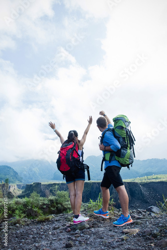 Mixed couple go trekking together, nature background