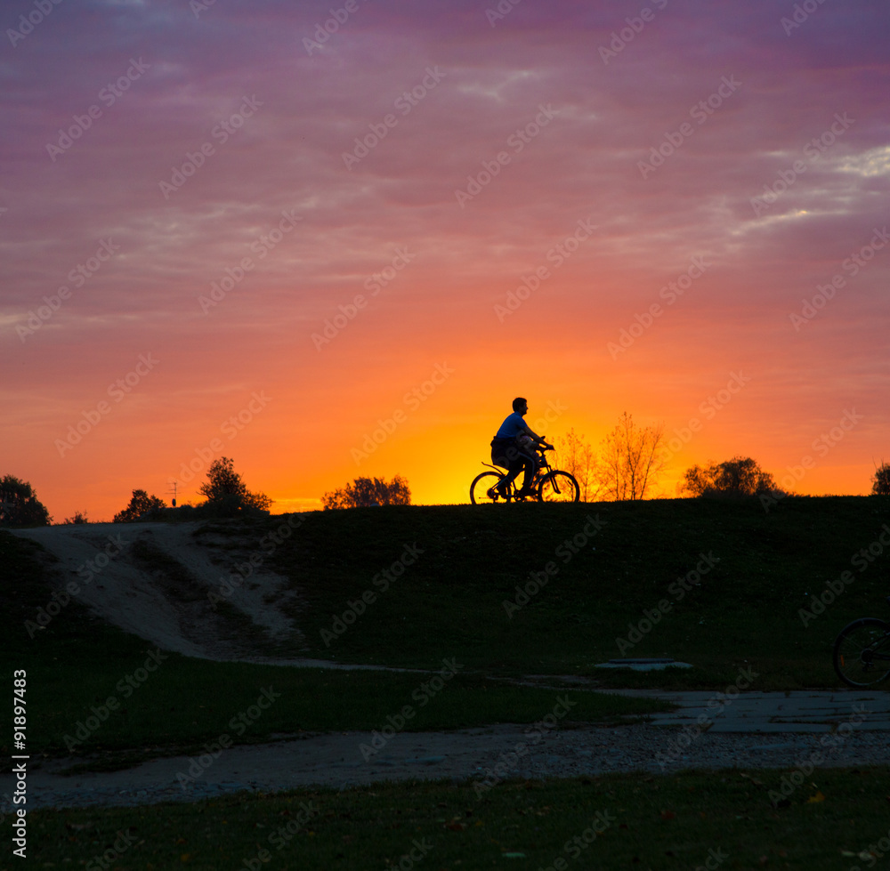 Silhouette of a man on bike at sunset Silhouette of a man on bike at sunset