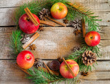 Christmas wreath made of fir branches, cones, red apples
