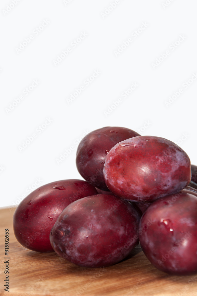 Fresh cleaned plums on the kitchen wooden board