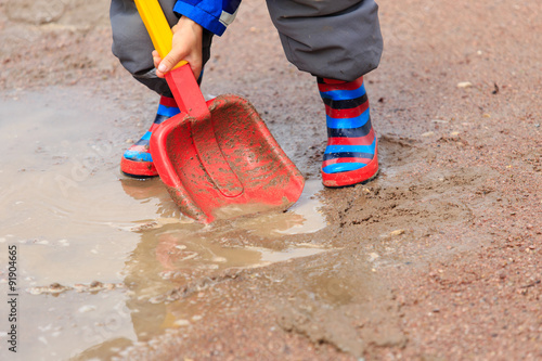 child playing in water puddle, kids outdoors