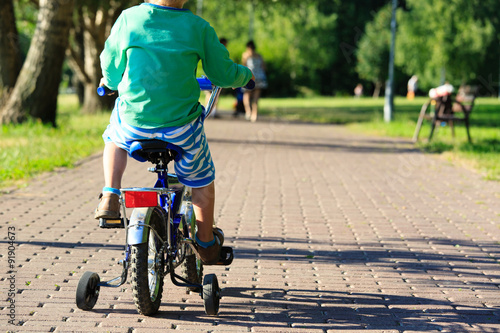 Fototapeta Naklejka Na Ścianę i Meble -  little boy riding bike in summer park