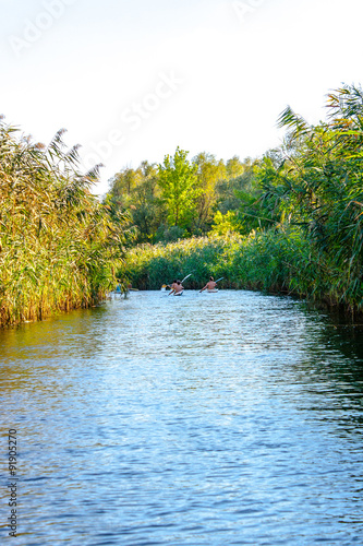 boys paddle canoes on the river