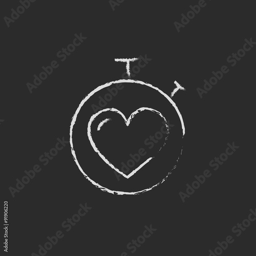 Stopwatch with heart icon drawn in chalk.